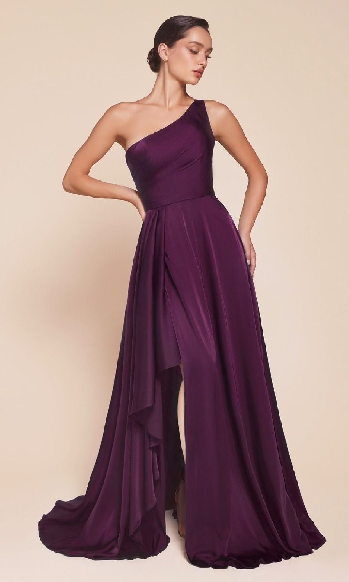 A woman models the Ladivine 7450, a one-shoulder, floor-length A-line prom dress in purple with a draped skirt and slit, standing against a neutral background. This formal gown radiates elegance and sophistication.